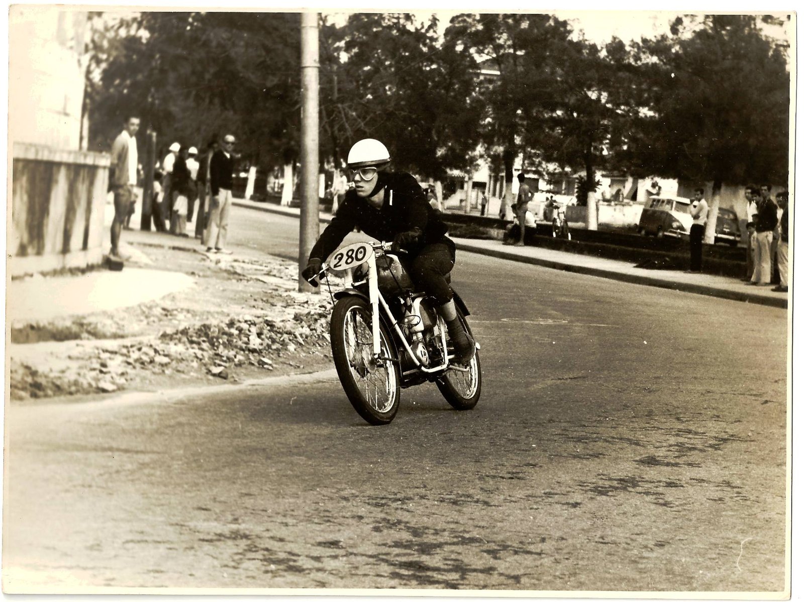 Corrida de motocicletas em Santos, 28 de junho de 1964. O piloto é o paulistano Luiz Celso Giannini, da categoria até 50 cm³. Ele faz a curva na avenida Siqueira Campos, Canal 4. Em 1971, Luiz Celso foi um dos primeiros brasileiros a disputar um GP válido pelo Mundial de Motociclismo. Estreou junto com Adú Celso Santos que, em 1973, tornou-se o primeiro brasileiro a ganhar um GP de moto. Foto gentilmente cedida por José Pedro Giannini, filho de Luiz Celso.