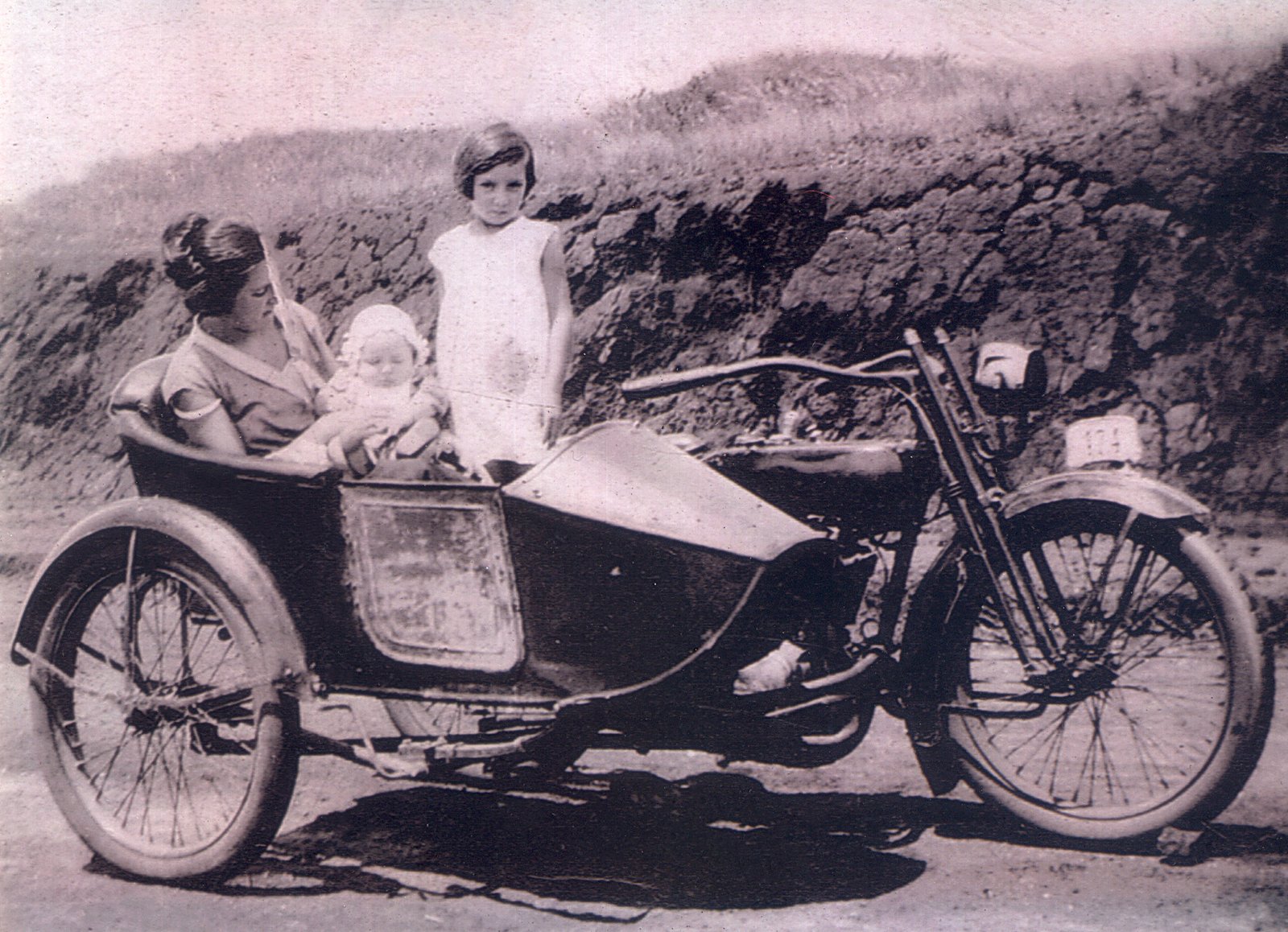 LINHA DO TEMPO - 1920 - Maria Carmona (Nena) irmã do grande piloto Felipe Carmona, e sua irmã Adelina. No colo de Nena, o pequenino recém nascido Edgard Soares. A moto com Side Car é uma Harley-Davidson 1927 que pertenceu a Francisco (Paco) Soares. A foto é de 1928 e pertence ao Acervo de Edgard Soares / Motostory